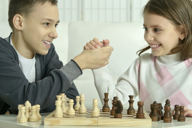 Little boy and little girl playing chess at home.Children playing chess