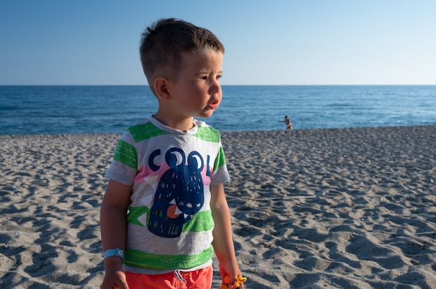 Ragazzino che cerca sua mamma sulla spiaggia.