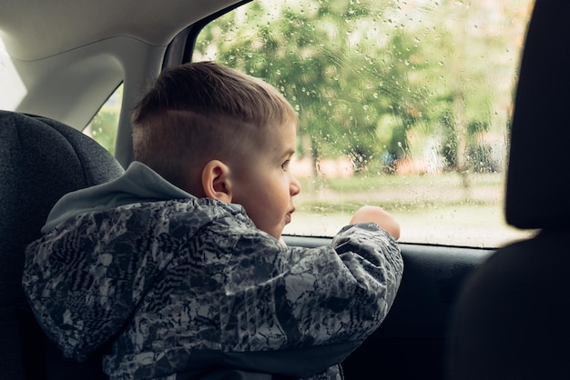 車の窓から見ている小さな男の子