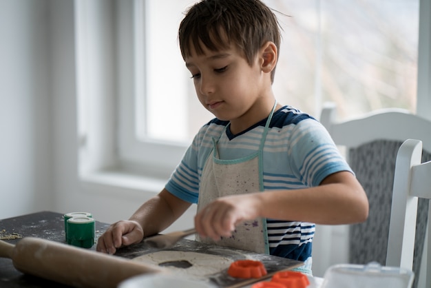 Little boy making dough for delicious sweet