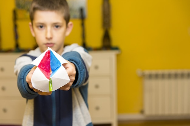 Little boy making paper toys at table indoors space for text Creative hobby