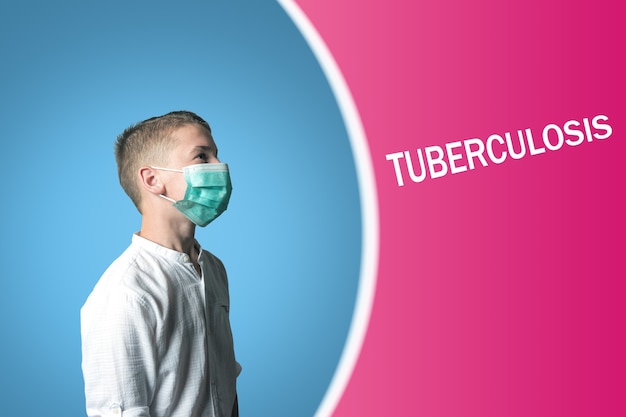 Little boy in a medical mask on a bright background with inscription TUBERCULOSIS