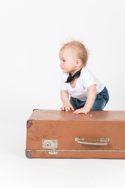 Little boy near the suitcase on the white space