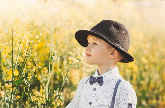 Little boy in an oilseed rape field with flowering