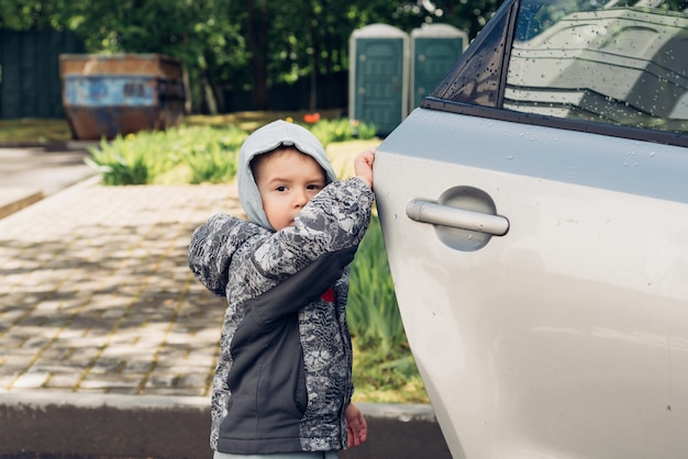 車の家族のドアを開ける小さな男の子が子供たちと一緒に旅行する