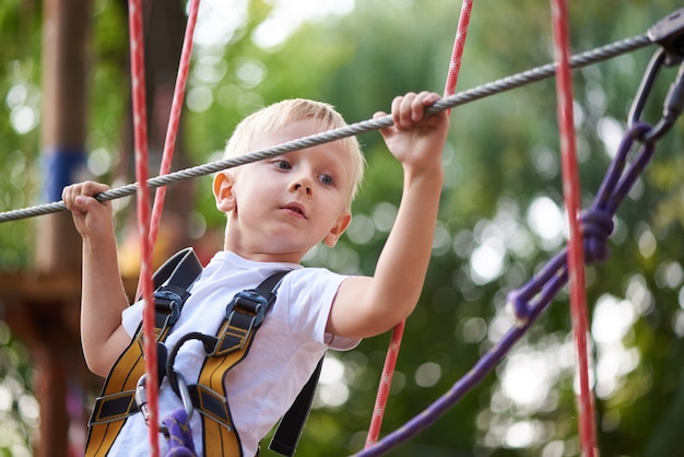 Little boy overcomes an obstacle in an amusement park 