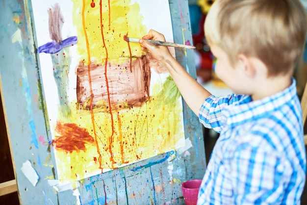 Photo little boy painting in art therapy