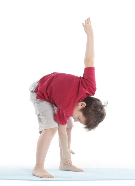 Little boy performs an exercise to stretch the musclesisolated on white