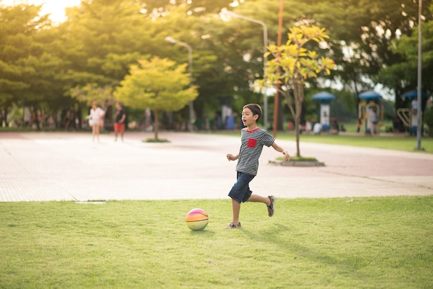 公園でボールを遊んでいる小さな男の子