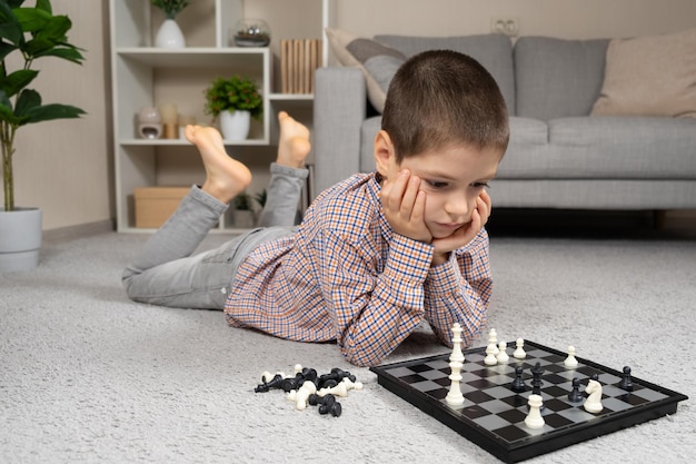 Photo little boy playing chess board games for children