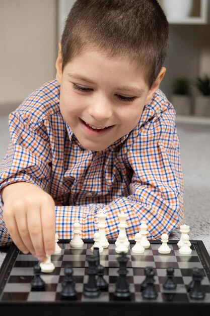 Маленький мальчик играет в шахматы, настольные игры для детей