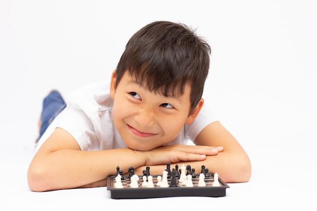 Little boy playing chess on the ground