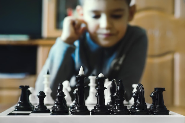 Little boy playing chess at home