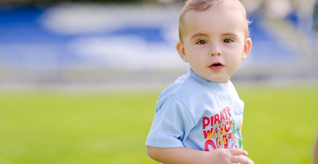 写真 サッカー場でサッカーをする小さな男の子