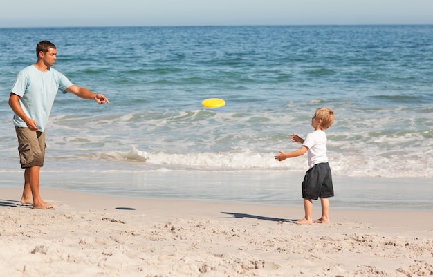 Little boy playing frisbee with his father