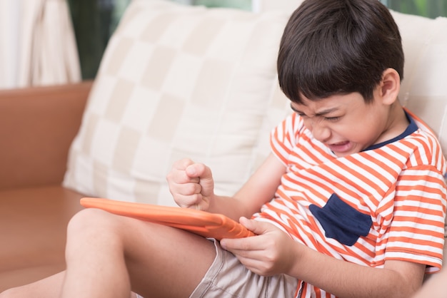 Little boy playing game on tablet