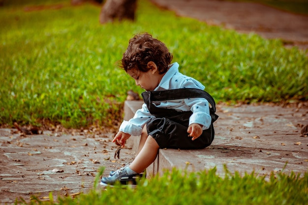 Little boy playing on the grass in a park