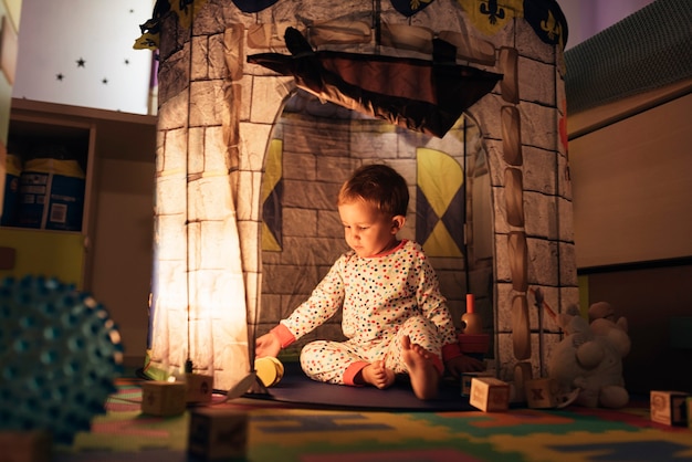 Фото Маленький мальчик играет в замок игрушки дома. концепция детства.