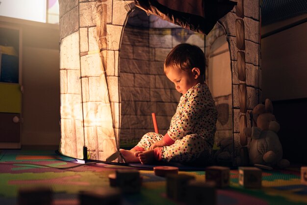 Little boy playing into castle toy at home. Childhood Concept.