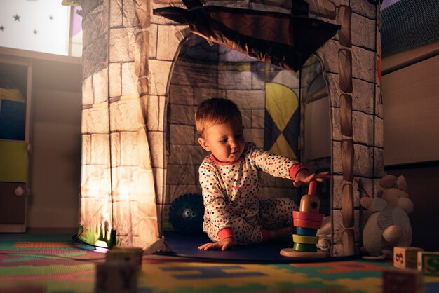 Photo little boy playing into castle toy at home. childhood concept.