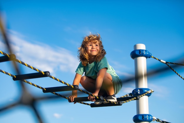 Little boy playing on the rope outdoor playground