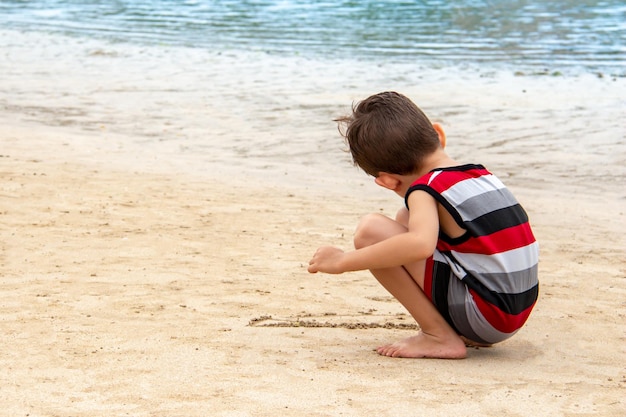 Little boy playing in the sand on the beach Child playing on the beach