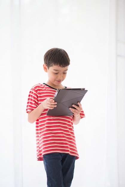 Little boy playing tablet at home