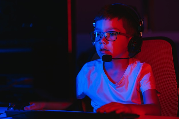 Little boy playing video game in the dark room