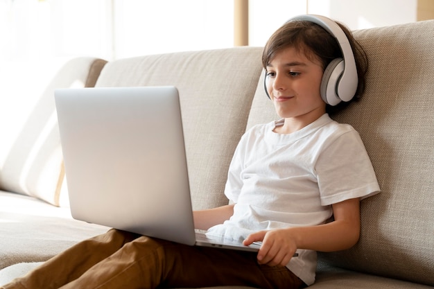 Little boy playing a video game on his laptop