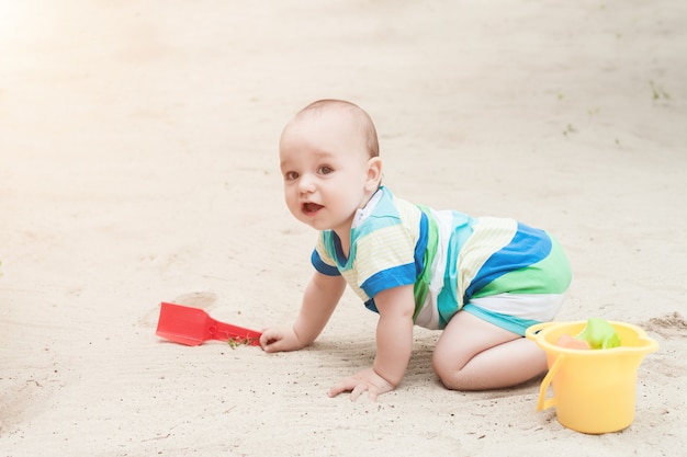 A little boy playing on a white sand