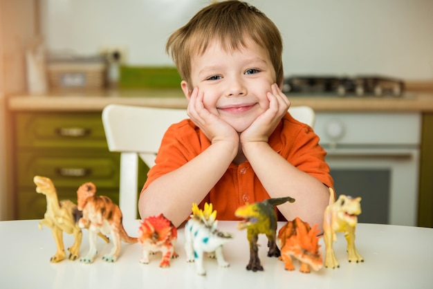 Ragazzino che gioca con i dinosauri. collezione lucertola