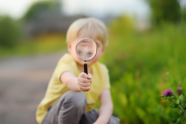 Little boy playing with magnifying glass.