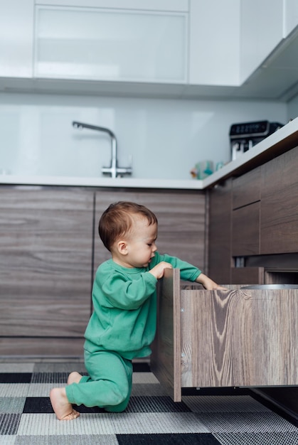 棚で遊ぶ小さな男の子床に座って屋内の遊び心のある子供