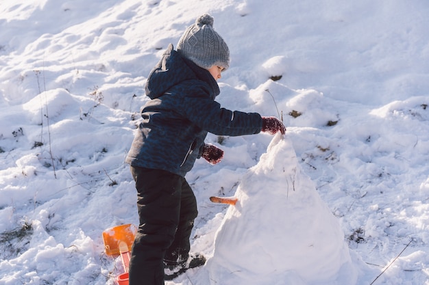 Little boy playing with snow