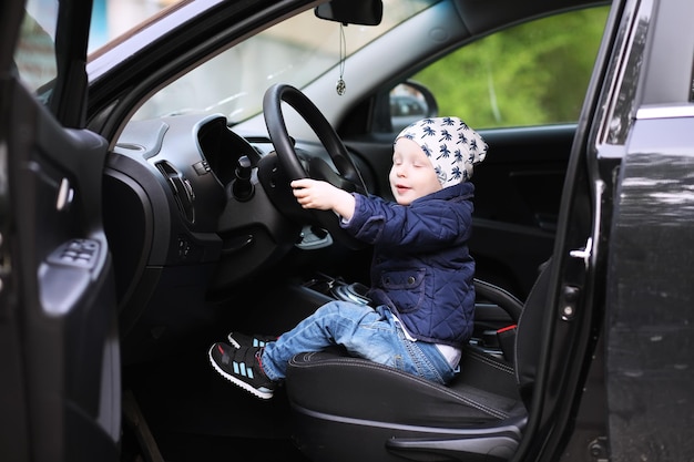 Little boy playing with a steering wheel in a car Hands of a small child driving a car driving instruction in childhood