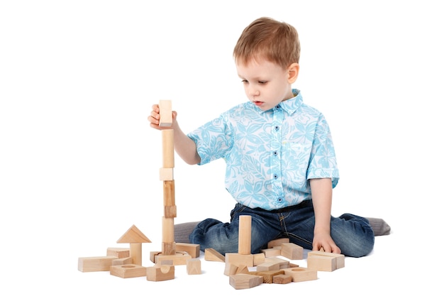 Little boy playing with wooden designer on the floor isolated on white background