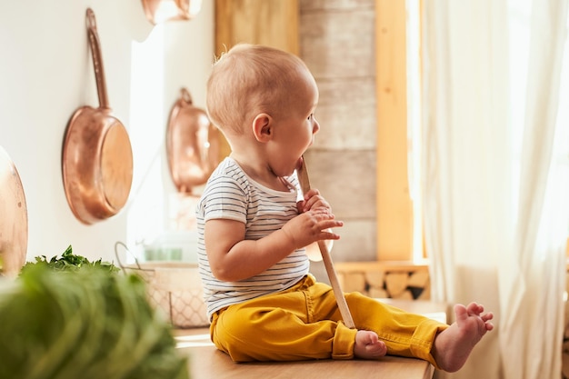 A little boy plays in the kitchen while mom cooks