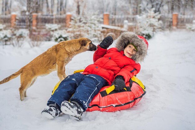 Little boy plays with a puppy in winter