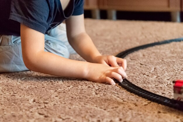 Little boy plays with toy railway