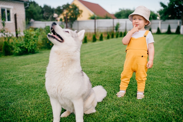 A little boy posing with the dog in the garden