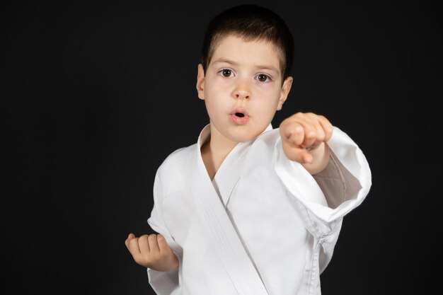 A little boy practices martial arts karate classes in kimono