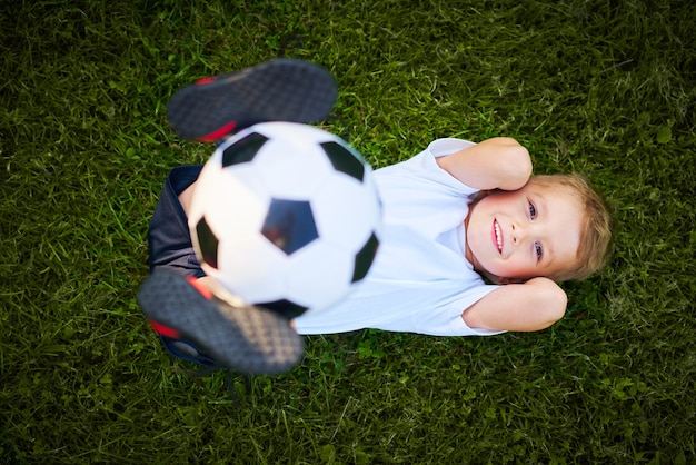 屋外でサッカーを練習する少年