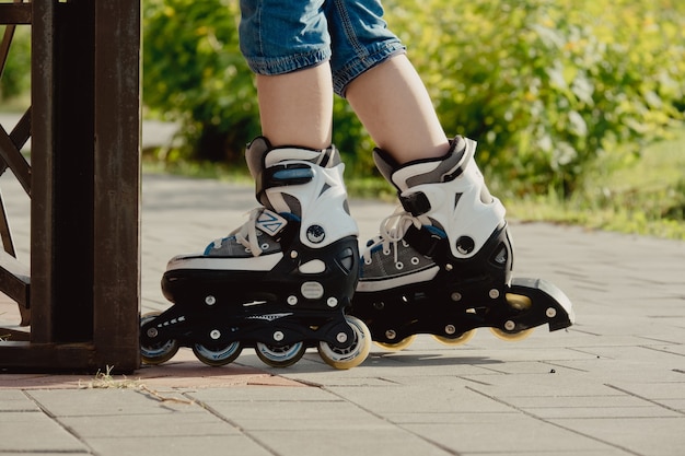 保護具とローラーの小さな男の子が公園の歩道に立っている、ローアングルビュー