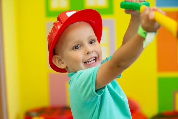 A little boy in a protective helmet plays a builder