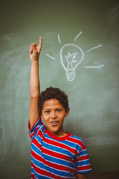 Little boy raising hand in classroom