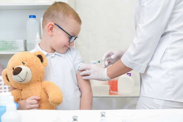 Little boy receiving vaccination at the clinic, close up. virus prevention