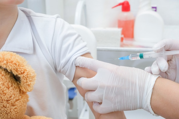 Little boy receiving vaccination at the clinic, close up. Virus prevention