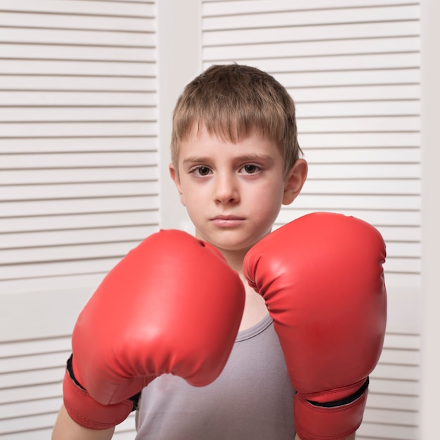 Photo little boy in red boxing gloves