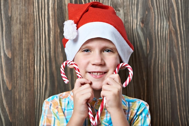 2 つのクリスマス キャンデー杖と赤い帽子の少年