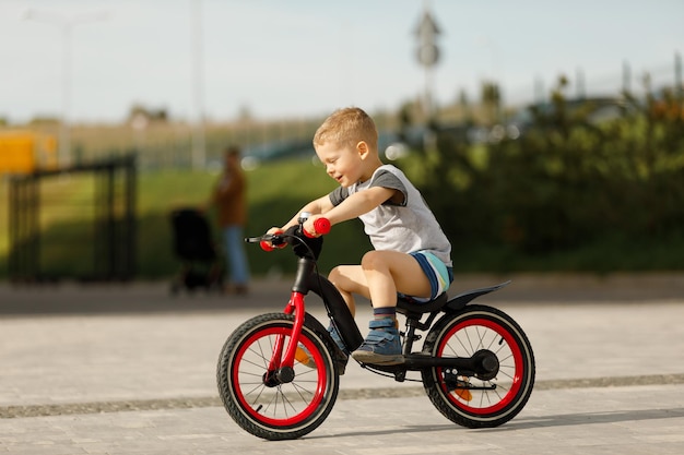 Маленький мальчик на велосипеде в городском парке